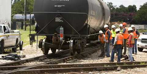 Railroad workers inspect tracks at the scene of a Capital Metro freight locomotive derailment in Austin, TX
